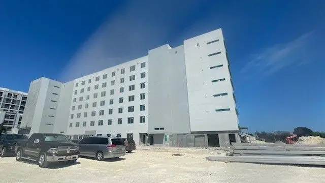 A large white building with cars parked in front of it.